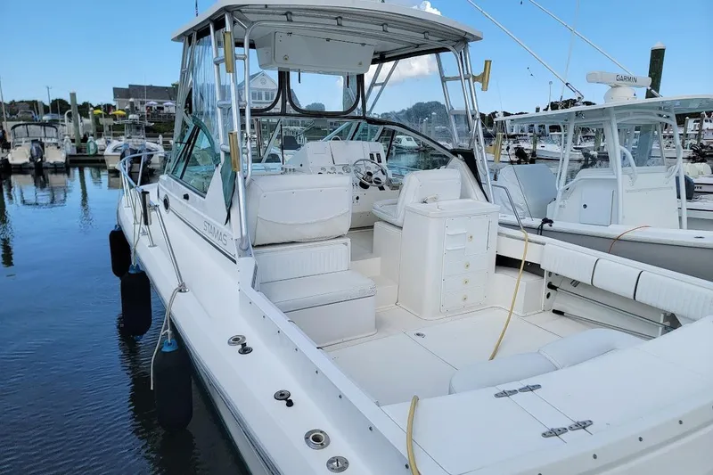 Slide: The Image of 2000 Stamas 310 Express boat docked at marina, showcasing spacious cockpit and helm area. - 27