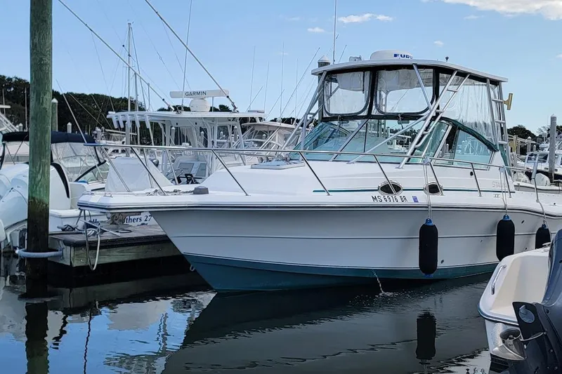 Slide: The Image of 2000 Stamas 310 Express boat docked at marina, featuring sleek design and fishing equipment. - 29