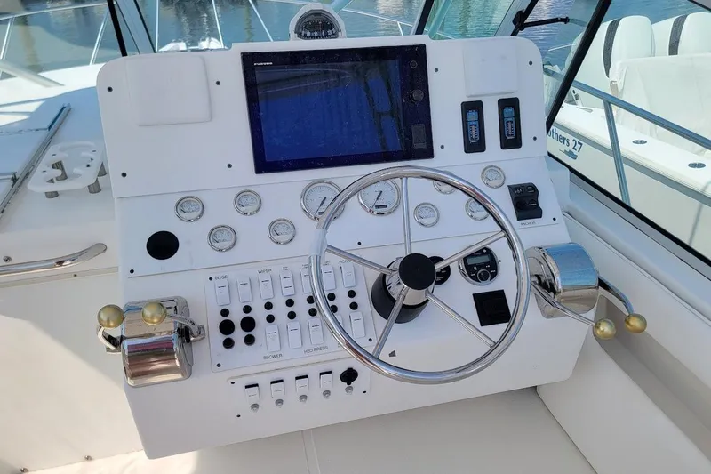Slide: The Image of Control panel of a 2000 Stamas 310 Express boat with steering wheel and gauges. - 4