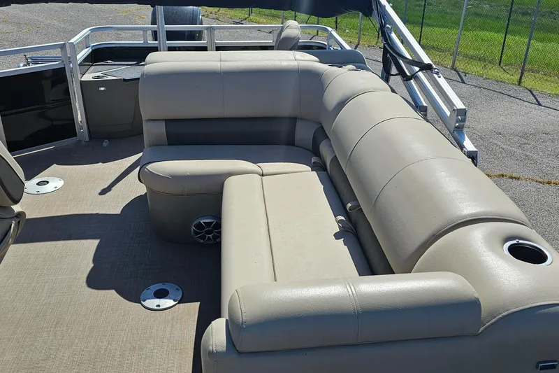 Slide: The Image of 2024 Sun Tracker SportFish 20 DLX pontoon boat with beige seating and cup holders. - 9