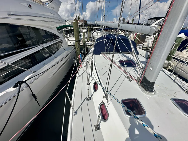 Slide: The Image of 2005 Catalina 36 sailboat docked beside a luxury yacht in a marina. - 11