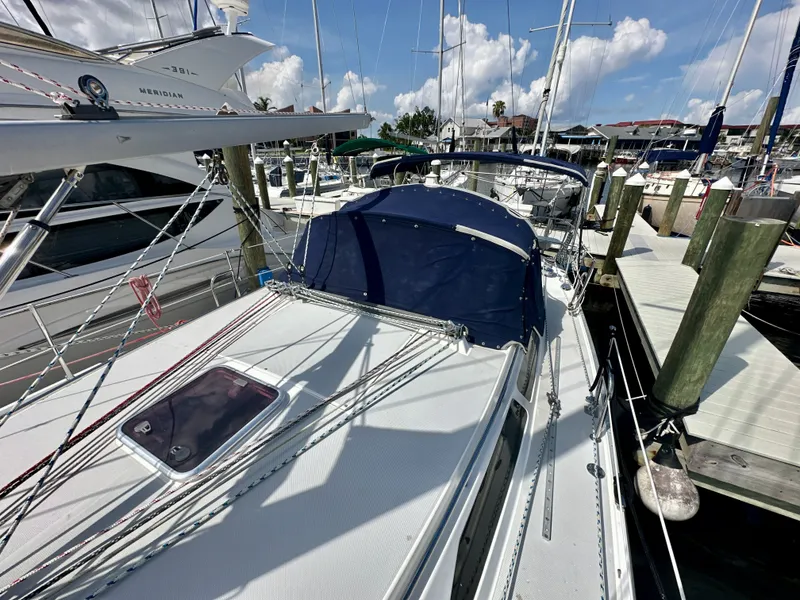 Slide: The Image of 2005 Catalina 36 sailboat docked at marina, featuring blue canvas cover and rigging. - 18
