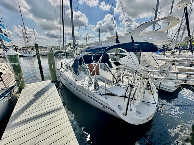 Slide: The Image of 2005 Catalina 36 sailboat docked at marina under partly cloudy sky. - 2