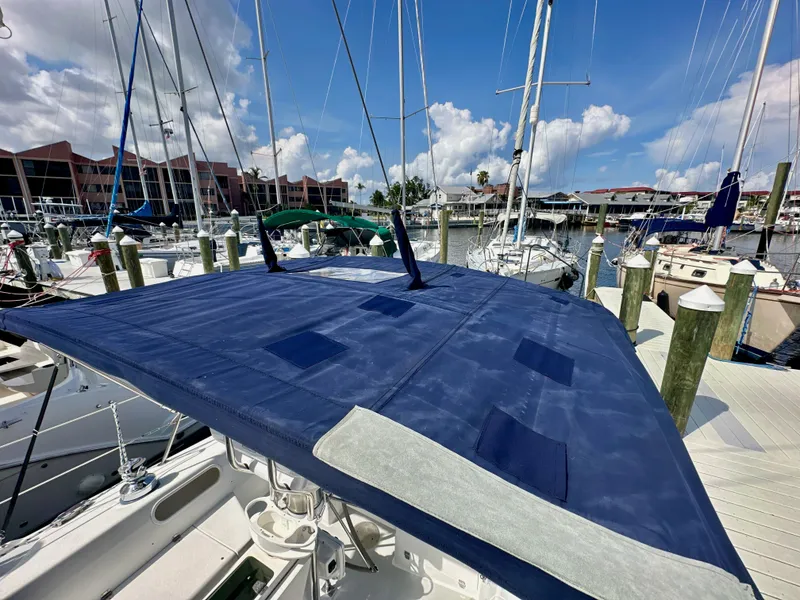 Slide: The Image of 2005 Catalina 36 sailboat with blue cover docked at marina under clear sky. - 20