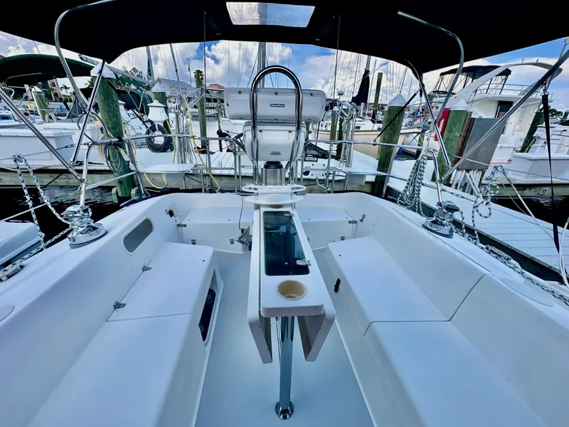 Slide: The Image of Cockpit of a 2005 Catalina 36 sailboat, featuring seating and steering wheel, docked at a marina. - 23
