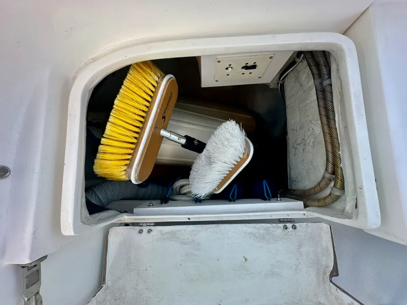 Slide: The Image of Storage compartment on a 2005 Catalina 36 sailboat with cleaning brushes and hoses. - 26