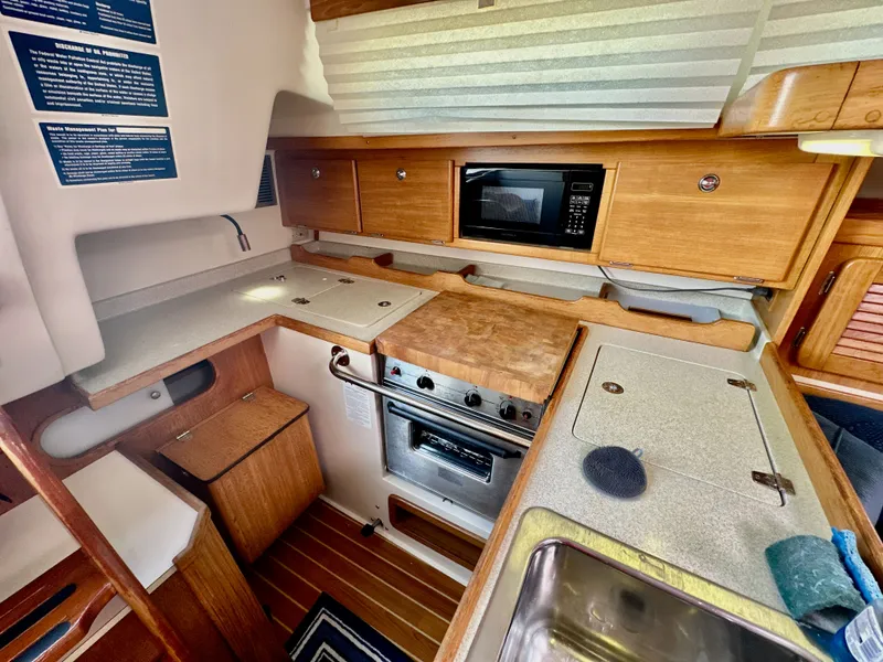 Slide: The Image of Interior of a 2005 Catalina 36 sailboat kitchen with wooden cabinetry and appliances. - 40