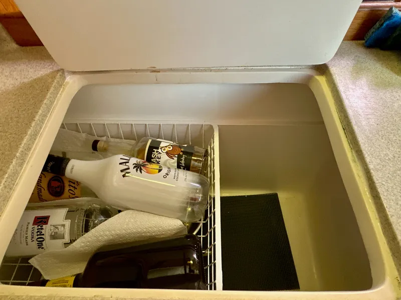 Slide: The Image of Open cooler on Catalina 36 yacht with assorted liquor bottles inside. - 44