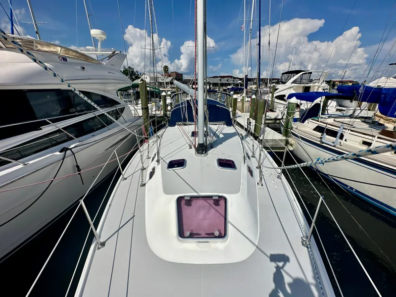 Slide: The Image of 2005 Catalina 36 sailboat docked at marina, surrounded by other boats under a clear blue sky. - 8