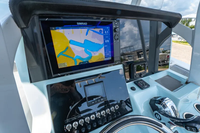 Slide: The Image of 2021 Sea Pro 239 Center Console dashboard with Simrad navigation display and controls. - 10