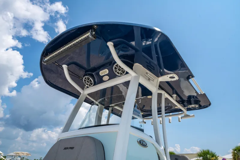 Slide: The Image of 2021 Sea Pro 239 Center Console boat with T-top and speakers under blue sky. - 11