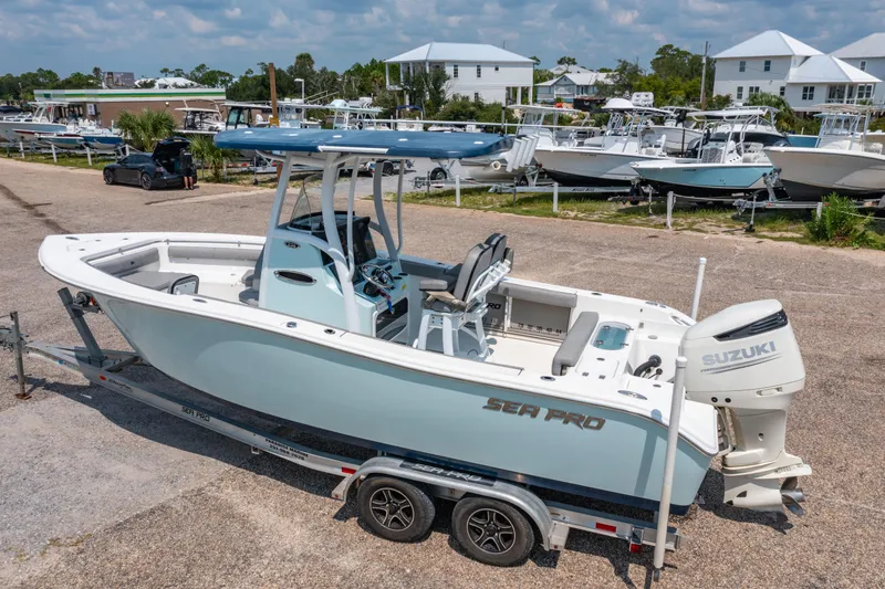 Slide: The Image of 2021 Sea Pro 239 Center Console boat on trailer, parked near marina. - 2