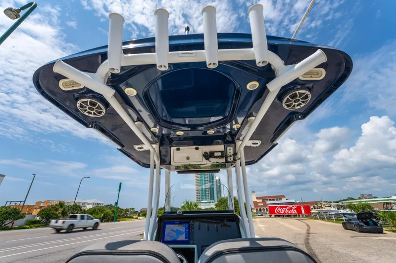 Slide: The Image of 2021 Sea Pro 239 Center Console boat with T-top, parked near a road under a blue sky. - 23