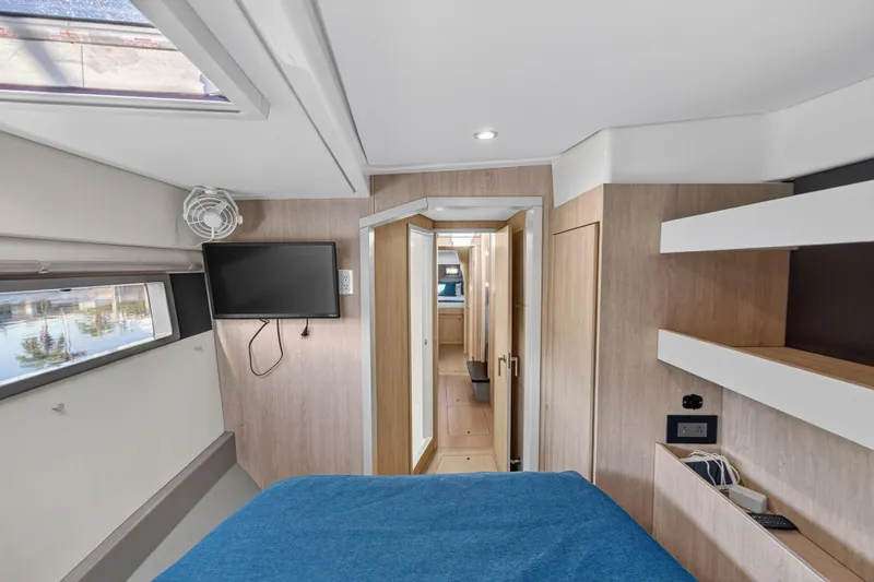 Slide: The Image of Interior of 2018 Leopard 51 Powercat cabin with modern design, TV, and blue bedding. - 101