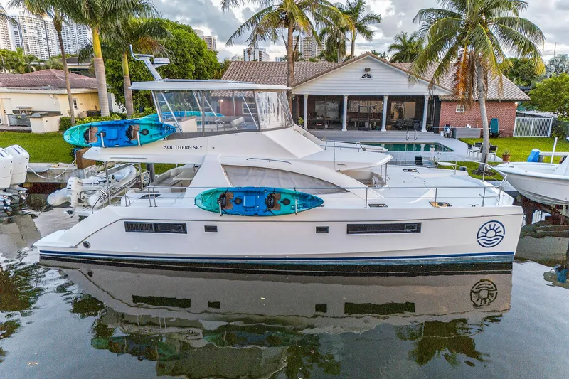 Slide: The Image of 2018 Leopard 51 Powercat docked with kayaks, surrounded by palm trees and waterfront homes. - 102