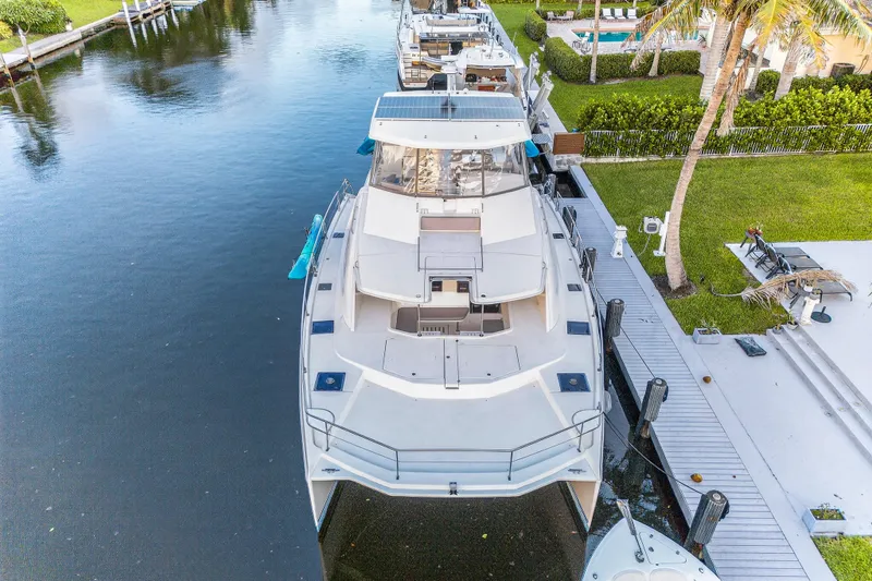 Slide: The Image of 2018 Leopard 51 Powercat docked by a waterfront property with lush greenery. - 104