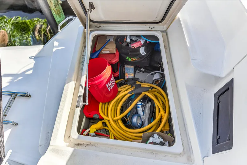 Slide: The Image of Storage compartment on 2018 Leopard 51 Powercat with tools, bucket, and yellow hose. - 40
