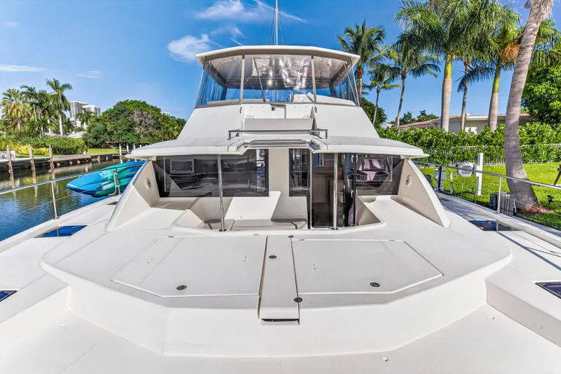 Slide: The Image of 2018 Leopard 51 Powercat yacht docked near palm trees, showcasing sleek design and spacious deck. - 49