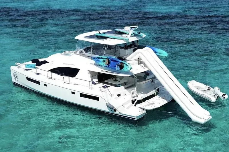 Slide: The Image of 2018 Leopard 51 Powercat yacht with slide and kayak on turquoise water. Southern Sky Catamaran Brokerage - 6