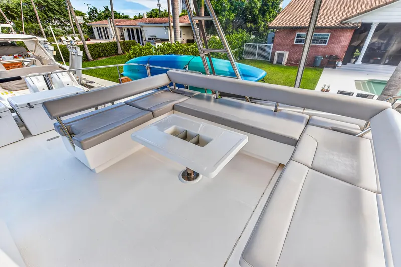 Slide: The Image of Outdoor seating area on 2018 Leopard 51 Powercat yacht with cushioned benches and table. - 63
