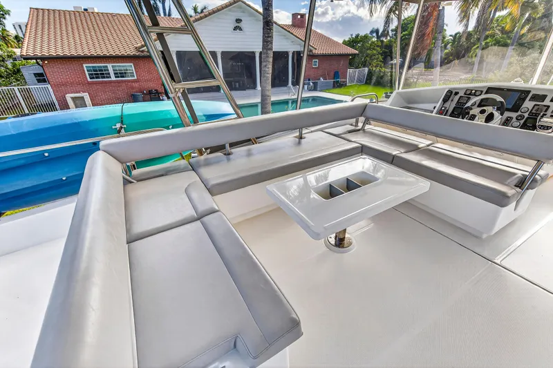 Slide: The Image of 2018 Leopard 51 Powercat interior with sleek seating and modern helm, near a poolside view. - 64