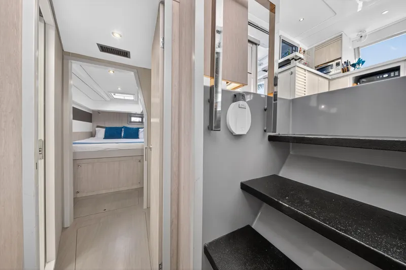 Slide: The Image of Interior of 2018 Leopard 51 Powercat, featuring modern bedroom and sleek staircase design. - 79