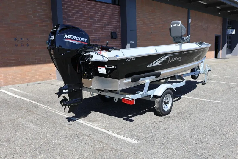 Slide: The Image of 2025 Lund SSV-18 boat on trailer with Mercury outboard motor in parking lot. - 12