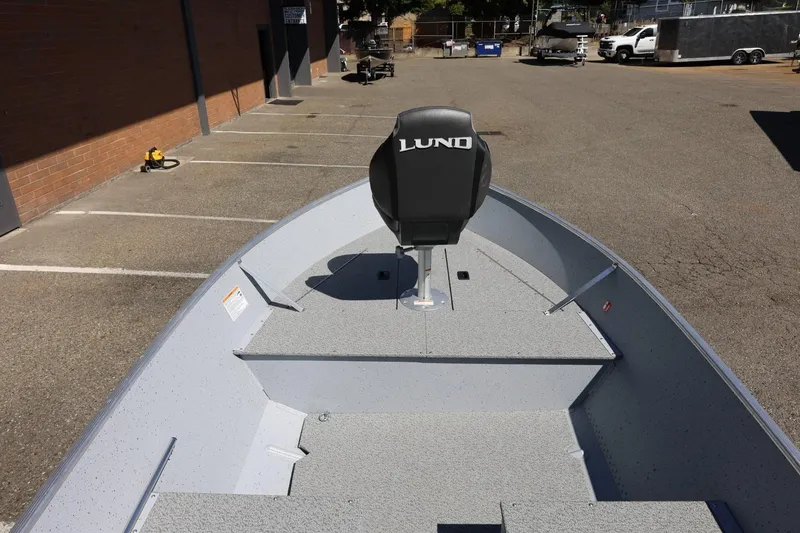 Slide: The Image of 2025 Lund SSV-18 boat with a single seat, parked in an outdoor lot. - 18