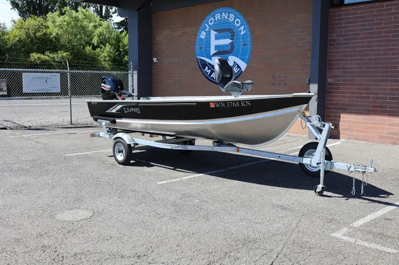 Slide: The Image of 2025 Lund SSV-18 boat on trailer in parking lot, near brick building. - 3
