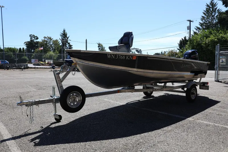 Slide: The Image of 2025 Lund SSV-18 boat on trailer in parking lot, sunny day. - 8