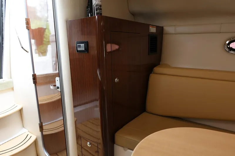 Slide: The Image of Interior of 2014 Regal 30 Express boat with wood paneling and beige seating. - 43