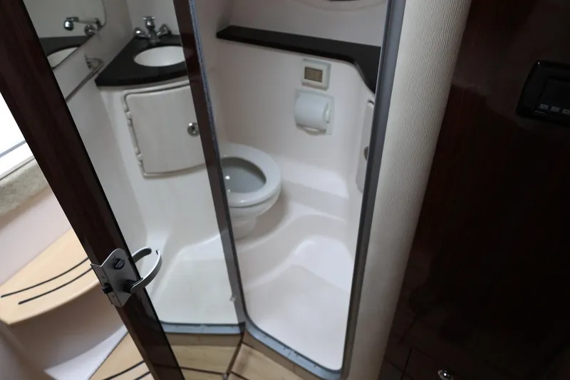 Slide: The Image of 2014 Regal 30 Express boat bathroom with sink, toilet, and storage cabinet. - 45