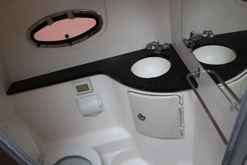 Slide: The Image of 2014 Regal 30 Express bathroom with sink, mirror, and porthole window. - 46