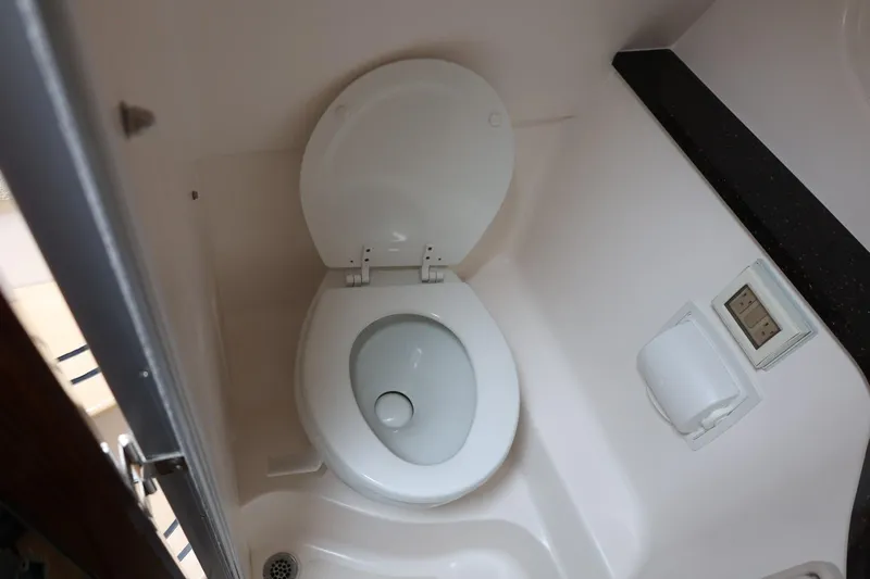 Slide: The Image of 2014 Regal 30 Express boat bathroom with toilet and control panel. - 47