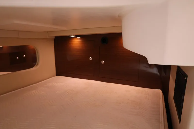 Slide: The Image of Interior cabin of 2014 Regal 30 Express boat with cozy lighting and wood paneling. - 49