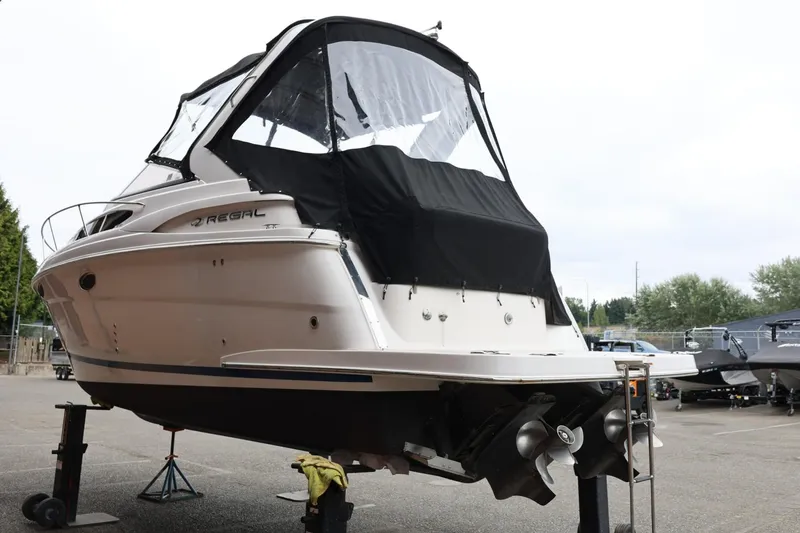 Slide: The Image of 2014 Regal 30 Express boat on stands, covered, in a parking area. - 5