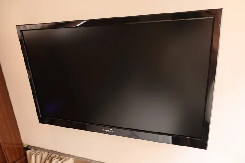 Slide: The Image of Flat-screen TV mounted on a 2014 Regal 30 Express boat interior. - 55