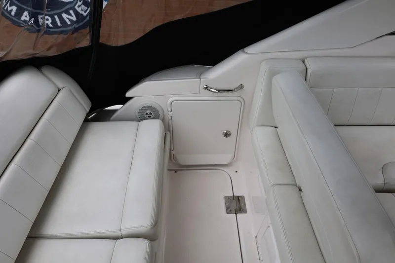 Slide: The Image of Interior seating of 2014 Regal 30 Express boat with white upholstery and storage compartment. - 62