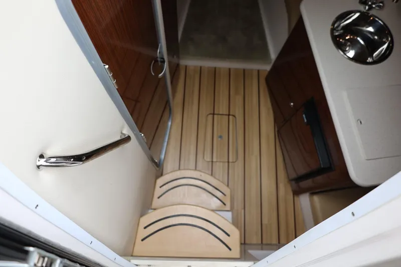 Slide: The Image of Interior of 2014 Regal 30 Express boat with wooden flooring and compact kitchenette. - 75