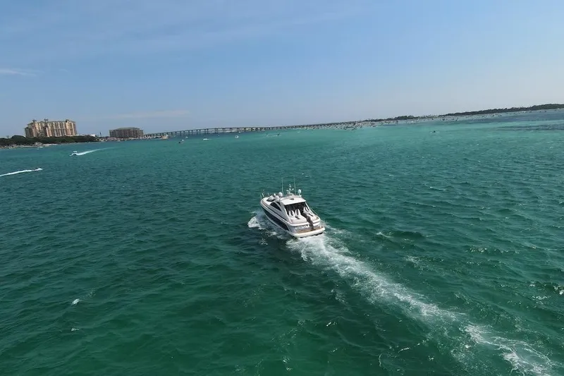 Slide: The Image of 2009 Fairline 52 Targa yacht cruising on turquoise waters near a coastal cityscape. - 3