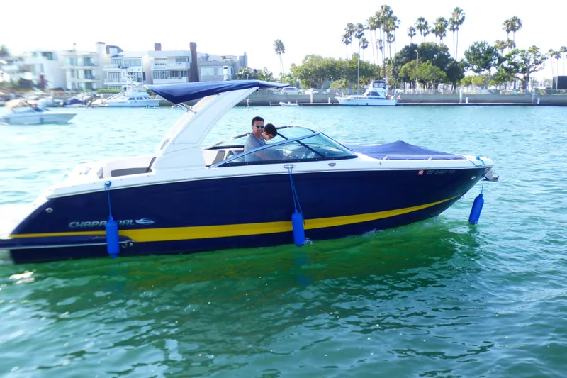 Slide: The Image of 2018 Chaparral 267 SSX boat cruising on a sunny day near waterfront homes. - 1