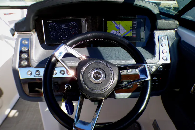 Slide: The Image of 2018 Chaparral 267 SSX boat dashboard with steering wheel and navigation displays. - 17