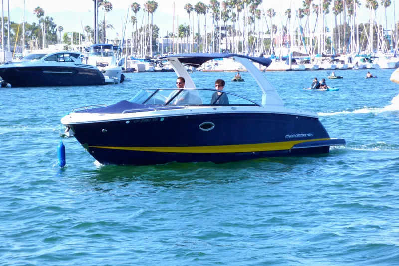 Slide: The Image of 2018 Chaparral 267 SSX boat cruising in a marina with palm trees in the background. - 5
