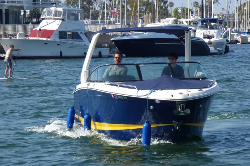 Slide: The Image of 2018 Chaparral 267 SSX boat cruising in a marina with paddleboarder nearby. - 6