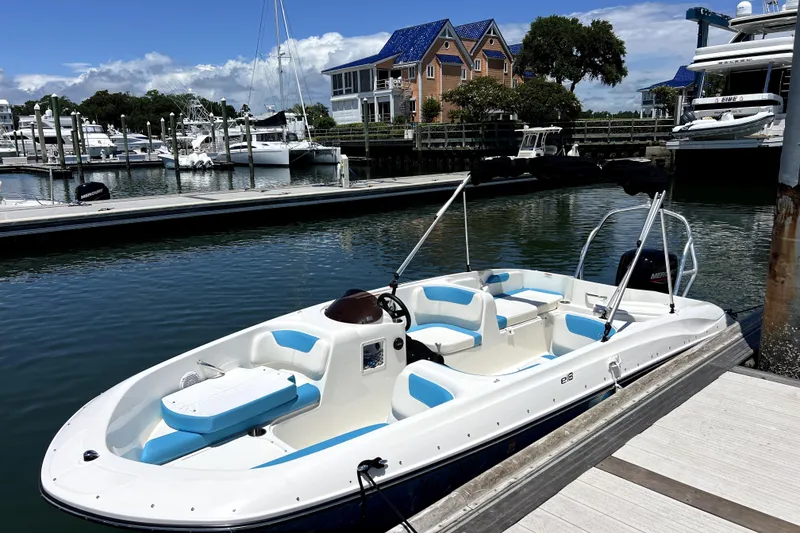 Slide: The Image of 2022 Bayliner Element E18 boat docked at a marina with scenic waterfront view. - 10