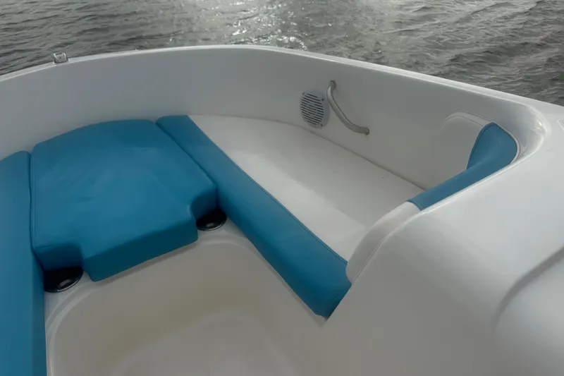 Slide: The Image of 2022 Bayliner Element E18 boat interior with blue seating, on water. - 12