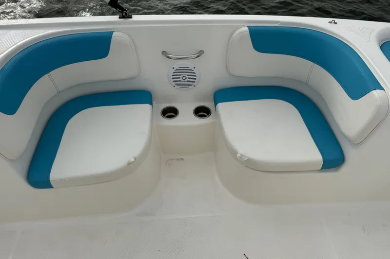 Slide: The Image of 2022 Bayliner Element E18 boat seating with blue and white cushions, cup holders, and speaker. - 14