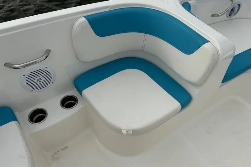 Slide: The Image of 2022 Bayliner Element E18 boat interior with blue and white seating, cup holders, and speaker. - 15