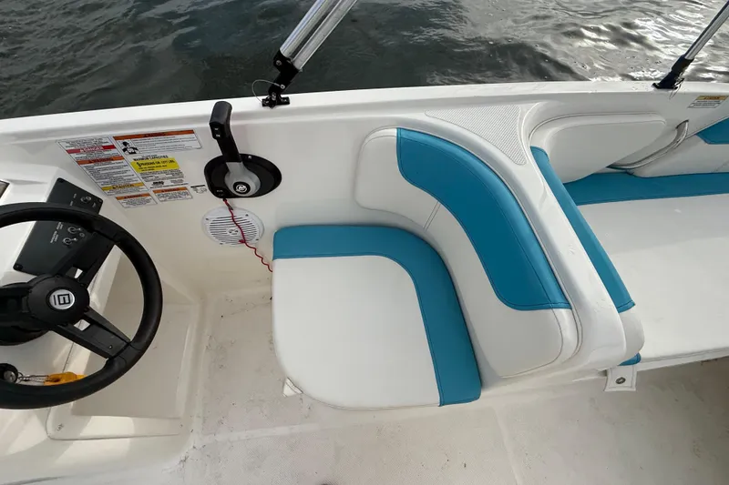 Slide: The Image of 2022 Bayliner Element E18 boat interior with blue and white seating, steering wheel, and controls. - 21