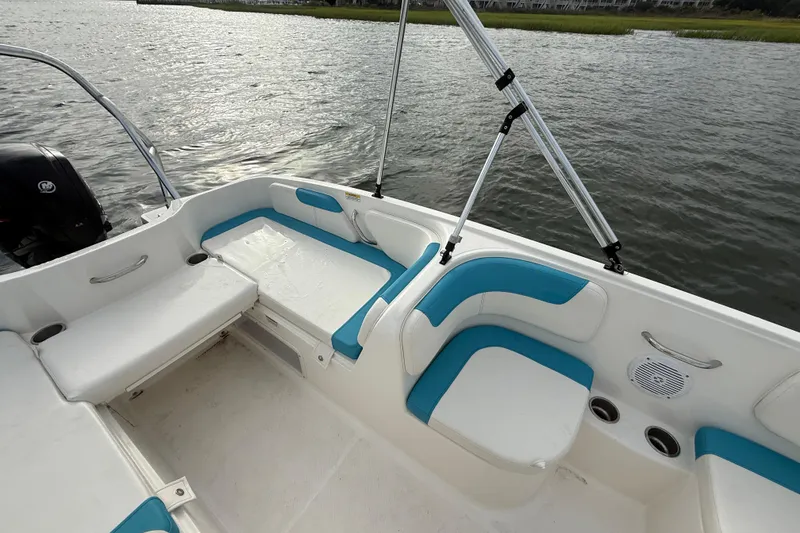 Slide: The Image of 2022 Bayliner Element E18 boat interior with white and blue seating on the water. - 23
